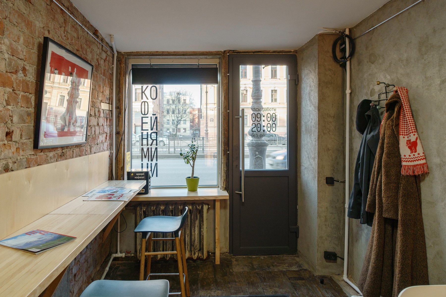 Inside Coffee Mini, looking toward the street window and door — both carry the elongated wordmark and signage.